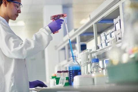 Scientist in laboratory using electronic pipette Stock Photos