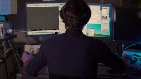Scientist in a laboratory works on an electron microscope Stock Footage