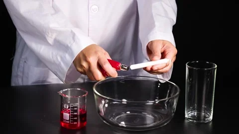 Scientist lighting white candle with red lighter inside empty glass bowl on.. Stock-Footage 332688883