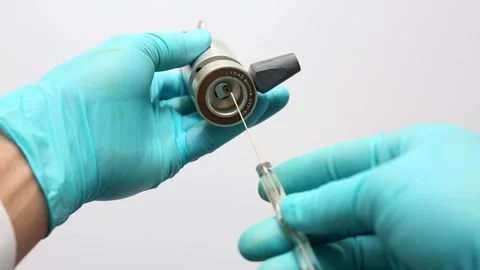 Scientist loading sample into HPLC injector valve using a microsyringe. Stock Footage 322070615