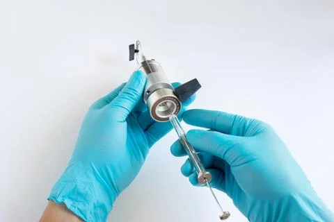 Scientist loading sample into HPLC injector valve using a microsyringe. Stock Photos