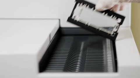 A scientist loads samples into a scanner for microarray analysis. Stock Footage 294564517