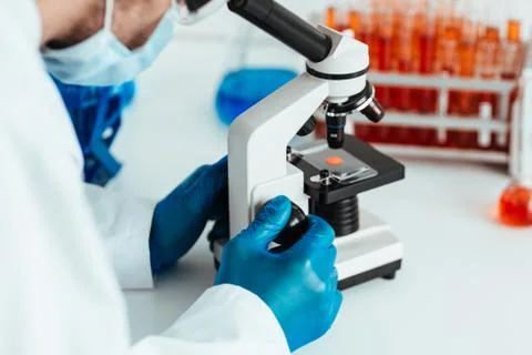 Scientist looking at a control sample through a microscope. Stock Photos