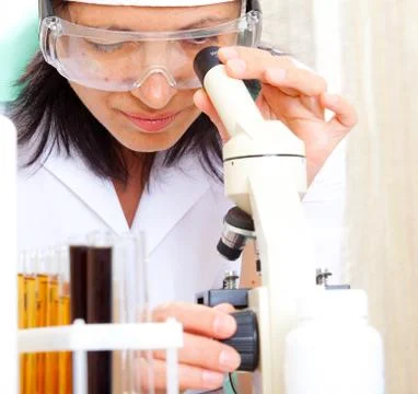Scientist looking into microscope Stock Photos