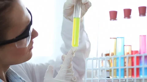 Scientist looking at test tubes with colorful chemicals HD Stock Footage