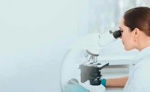 Scientist Looking Through Microscope and concentrate. Biological research Stock Photos