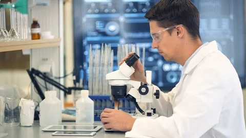 Scientist looking through a microscope in a laboratory Video stock 74936031