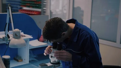 Scientist looking through a microscope in a laboratory Stock Footage 104924507