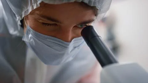 Scientist looking through microscope in laboratory. Researcher testing samples Stock Photos