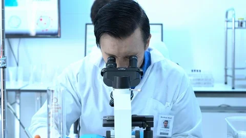 Scientist is looking through microscope in modern laboratory or medical center. Stock-Footage 106667013