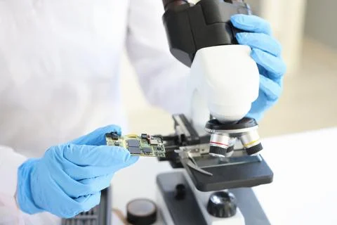 Scientist looking under microscope computer processor closeup 写真素材