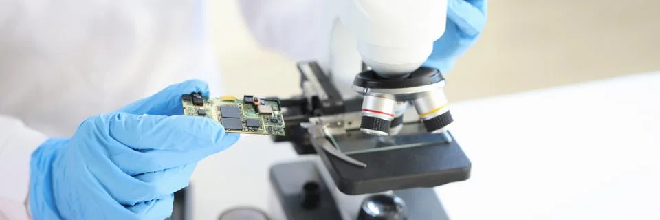 Scientist looking under microscope computer processor closeup 写真素材