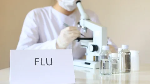 Scientist Looks at Biological Samples Under Microscope Researching Flu Stock Footage 127865195