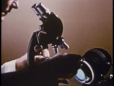 A scientist looks at cells under a microscope and an animation shows disease Stock Footage 75759421