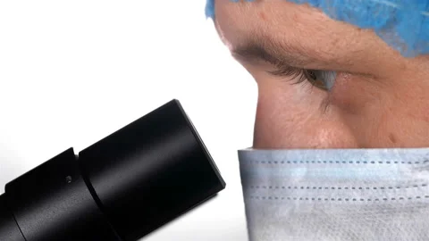 A scientist looks through the eyepiece of a microscope Stock Footage 101035123