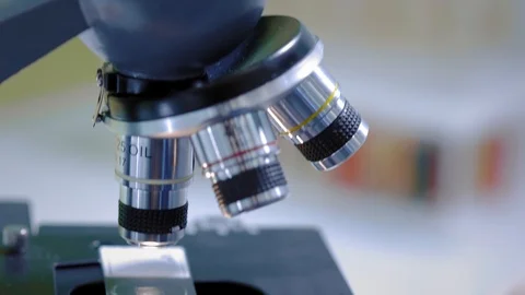 A scientist looks through a microscope. Changes samples. Carries out scientific Video stock 123292620