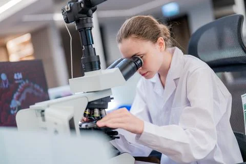 Scientist looks through microscope in laboratory during research work on sa.. Stock Photos
