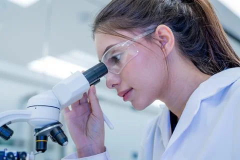 Scientist looks through microscope in laboratory during work hours Stock Photos