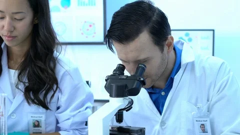 Scientist male is looking through microscope. Stock Footage 108640274