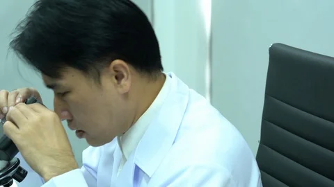 Scientist male is looking through microscope working in modern laboratory Video stock 108711148