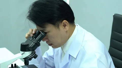 Scientist male is looking through microscope working in modern laboratory Video stock 108712231