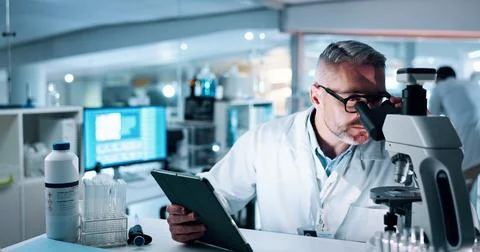 Scientist, man and microscope with tablet, analysis and medical research for Foto stock