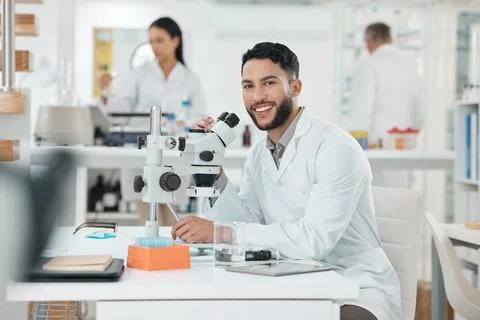 Scientist, man and portrait by microscope in lab study, stats or smile for Stock Photos
