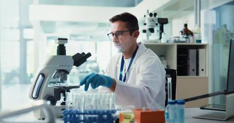 Scientist, man and sample by microscope in lab for medical research with Stock Photos