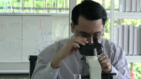 Scientist man is looking through microscope Stock Footage 177939509