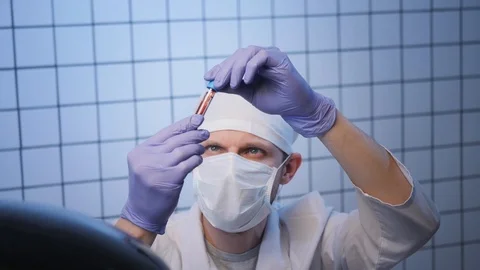 Scientist in mask looks at sample of coronavirus in lab Stock Footage 127214869