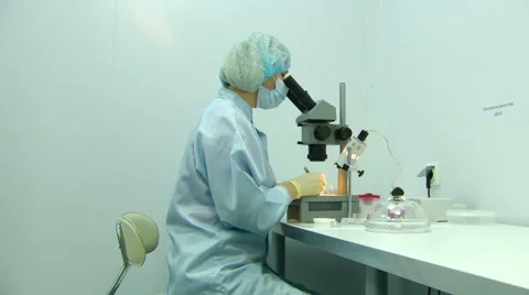 Scientist in the Mask in the Sterile Lab Working With Microscope on the Stock Footage 60999799