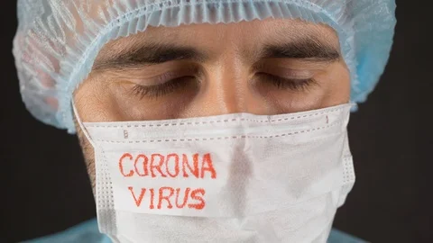 Scientist in a mask with the word "coronavirus" waving his head to the side Stock Footage