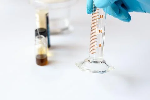 Scientist Measuring 10 ml Solvent in Graduated Cylinder for TLC Mobile Phase Stock Photos