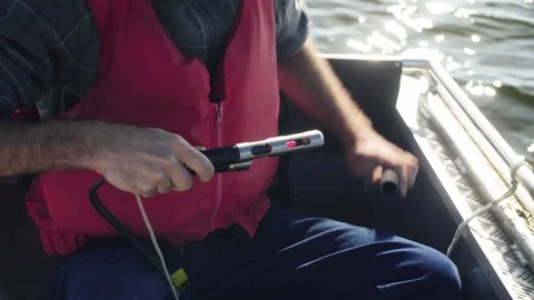 A scientist measuring the pH of the lake using a pH meter Stockbeeldmateriaal 93739390