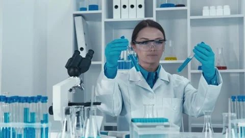 A scientist is meticulously analyzing test tubes in a modern laboratory setting Stock Footage 317023094