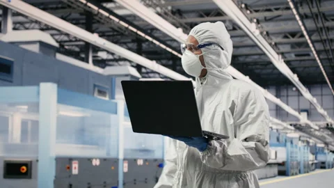 Scientist in microchip factory cleanroom uses laptop Stock Footage 333394727