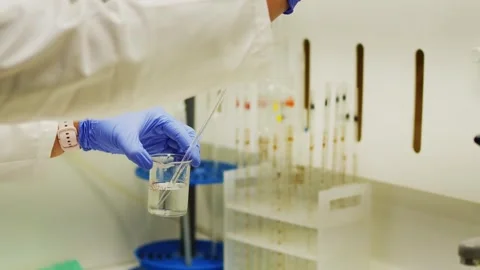 Scientist Mixing Chemical Solution in Flask During Laboratory Experiment in 4K Stock Footage 338165707