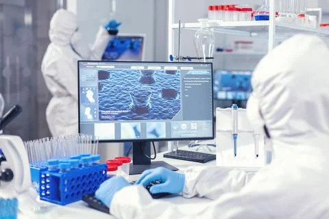 Scientist in modern lab working on computer during coronavirus Foto stock