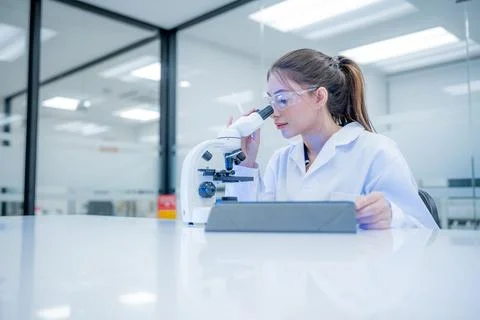 Scientist observes sample through microscope in laboratory during daytime w.. Stock Photos