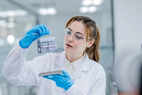 Scientist observes samples in laboratory while wearing gloves and protectiv.. Fotos de archivo