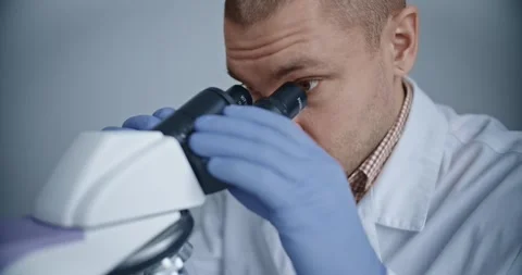 Scientist observes samples through microscope to draw conclusions Stock Footage 299903214