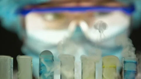 Scientist observing boiling process in test tubes, secret laboratory research 動画素材 104570899