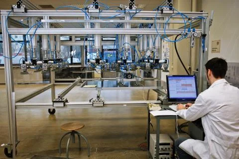 Scientist observing computer test on his laptop in a futuristic laboratoy Stock Photos