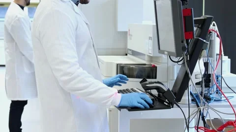 Scientist operating laboratory equipment analyzes data Stock Footage 296885999
