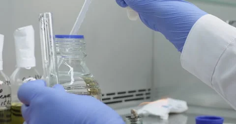Scientist or chemist work in a laboratory, drops liquid sample from a pipette Stock Footage 277602976