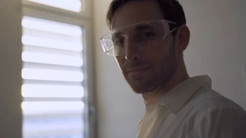 Scientist or doctor looking at camera while standing next to lab window Stock Footage 112619669