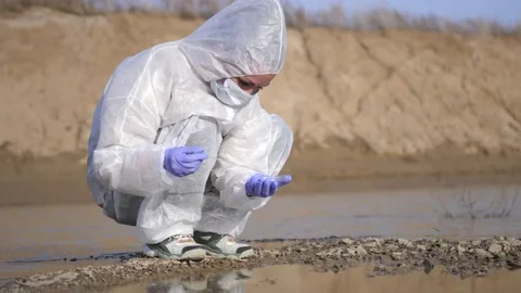 Scientist or ecology expert in protective costume with test tube taking probe Stock Footage 170290879
