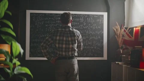 Scientist or mathematician thinks hard looking at a blackboard full of complex Video stock 314250229