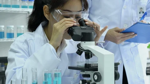 Scientist or pharmacist are looking through microscope working in modern lab. Stock Footage 129066632