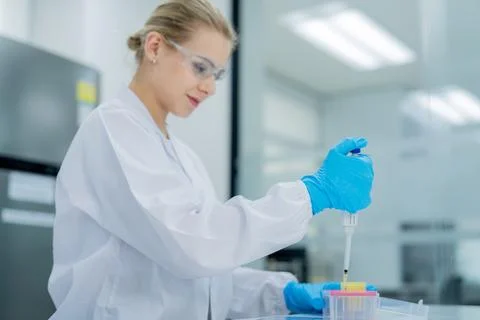 Scientist performs precise pipetting in laboratory setting during daylight .. Stock Photos